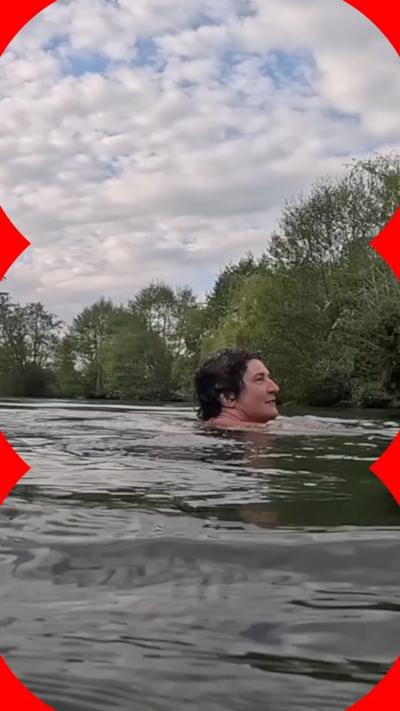 A person swims in a lake