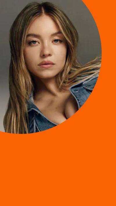 Sydney Sweeney poses with long brown hair, wearing silver and a denim jacket