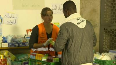 Volunteer hands supplies to migrant