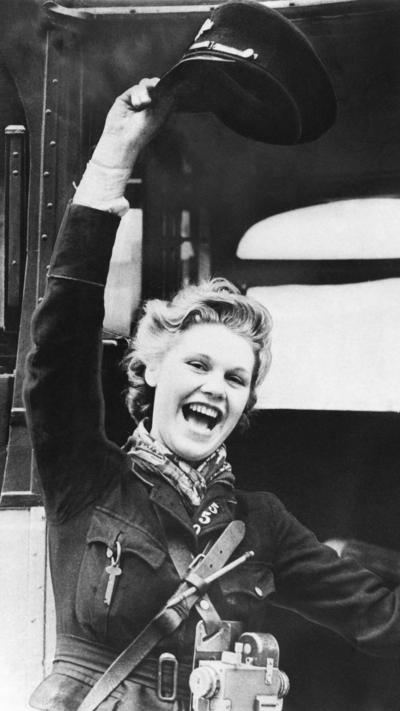 Black and white image of a bus conductor celebrating VE day in Glasgow.
