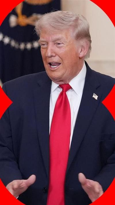 Donald Trump wears a black suit and red tie