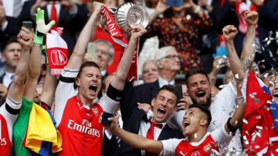 Per Mertesacker lifts the trophy with Laurent Koscielny