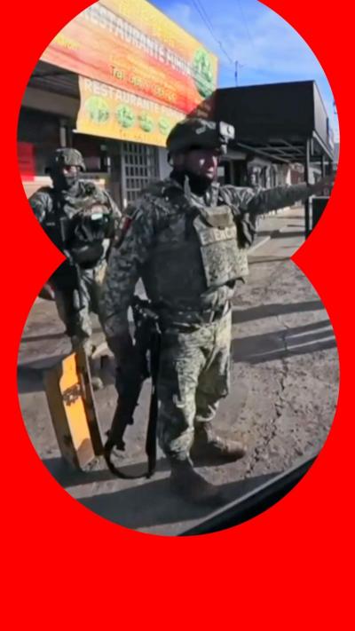 Military officers with guns on a street Culiacán, Mexico.