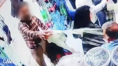 Man pours yoghurt over a woman in a shop