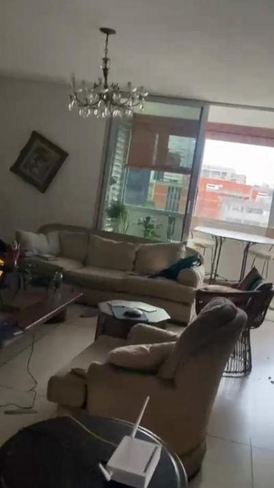 Cell phone video inside a living room filmed at an angle with photo frames and items moved.