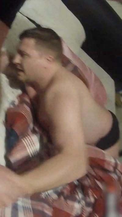 Alternative description
Man with brown hair in nothing but black boxer shorts on a bed with a police officer grabbing both his hands
