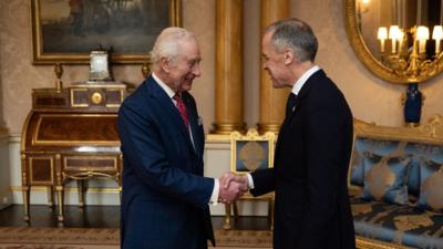 King Charles shakes hands with Mark Carney