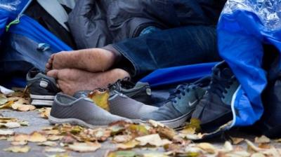 Migrant's feet poke out of a tent