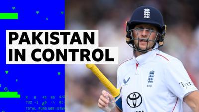 Joe Root holds his bat as he walks off the crease