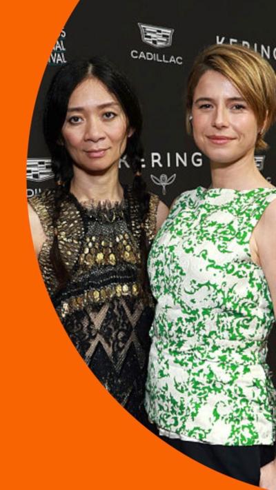 Chloe Zhao and Jessie Buckley look to the camera on the red carpet.