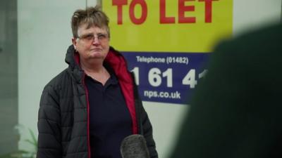 Woman beside a to let sign