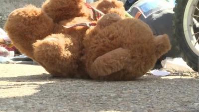 Teddy bear next to buggy wheels