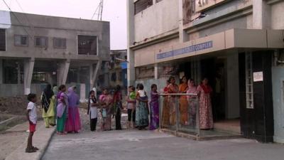 Women queue to use the public toilet in Mumbai