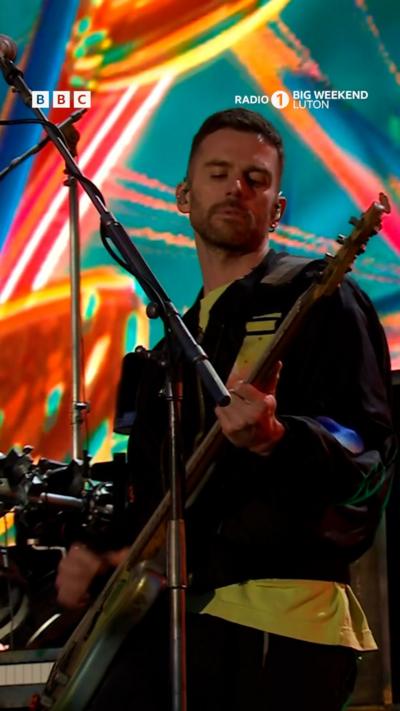Coldplay at Radio 1 Big Weekend festival. The stage is lit up with colour.