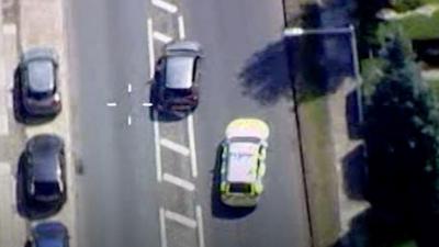 Aerial image from police helicopter shows police car in pursuit of a silver vehicle.