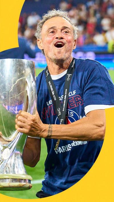 PSG manager Luis Enrique holding the UEFA Super Cup trophy. He is wearing a blue shirt and has a gold medal around his neck.
