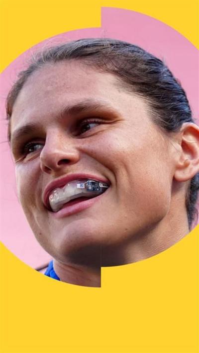 A woman with tied-back brown hair wears a mouthguard with a flashing component