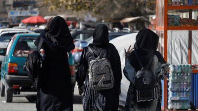 Three female students walking away from university