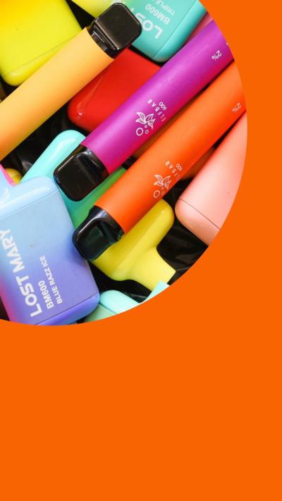 Colourful vape packaging is on display on a shelf in a shop