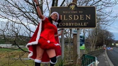 Mary Taylor stood by village sign