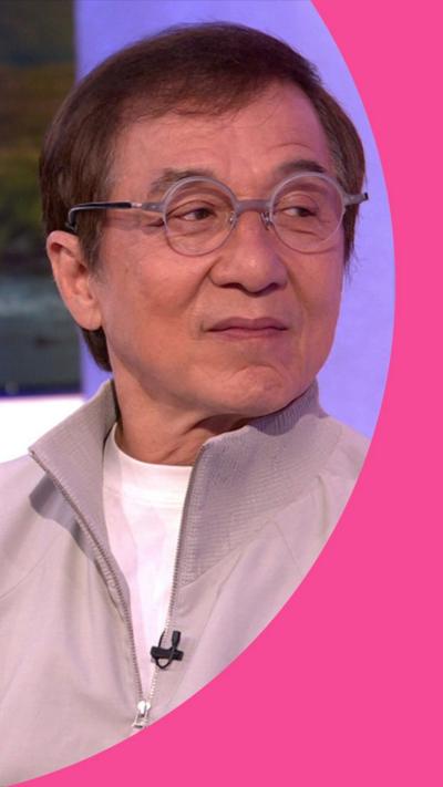 Jackie Chan wears round glasses and a beige tracksuit