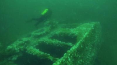 Diver hovering above a sunken fishing trawler