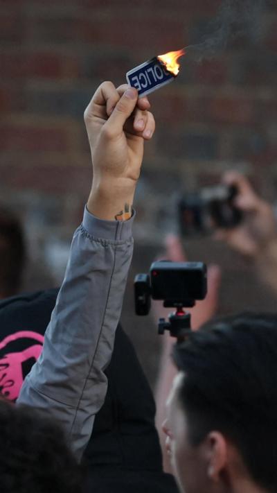 Protester holds flaming police badge