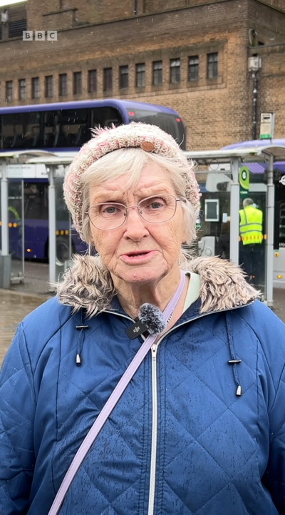 Marlene Ames, an older woman, wearing a blue coat, looking at the camera
