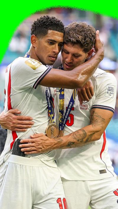 Jude Bellingham and John Stones hug at the end of England's World Cup third place match against France.