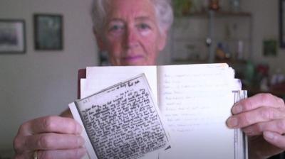 Woman holding a letter and diary