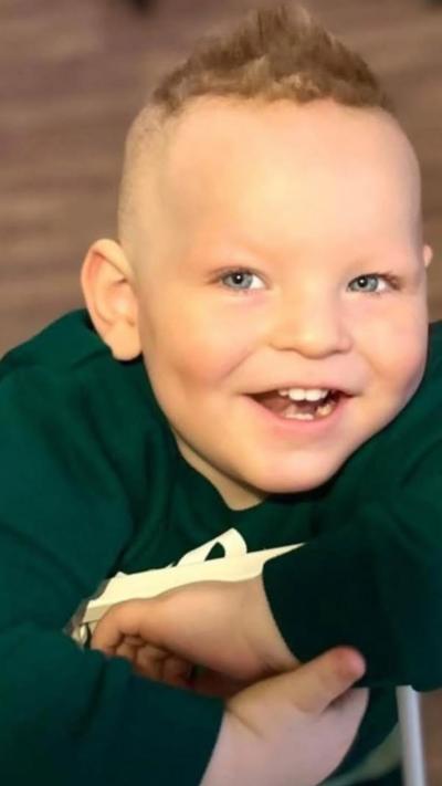A small boy smiling in a green top