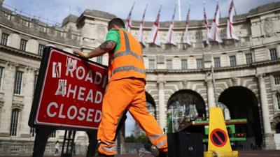 A man moves a road sign, following the funeral of Britain's Queen Elizabeth, in London, Britain September 20, 2022