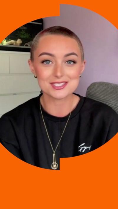 Erin Laverty, with closely cropped hair wearing a baggy black jumper, looking straight to camera.