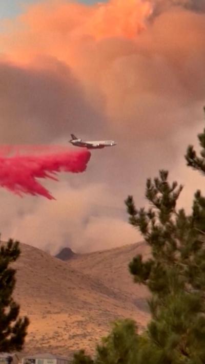 An airtanker drops retardant over a wildfire.