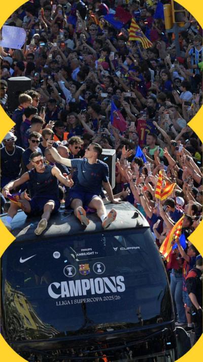 Barcelona players sat on top of a Barcelona branded bus during a victory parade with crowds of fans surrounding.