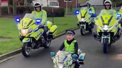 Harry riding his bike alongside police officers on motorbikes