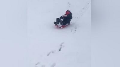 A child sledging in the snow