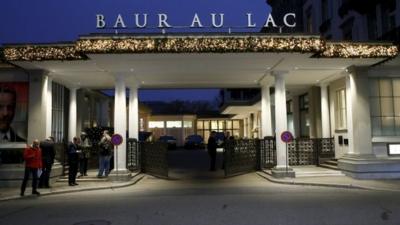 Members of the media stand outside the Baur au Lac hotel