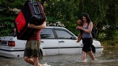 People evacuating from floodwaters in Kherson