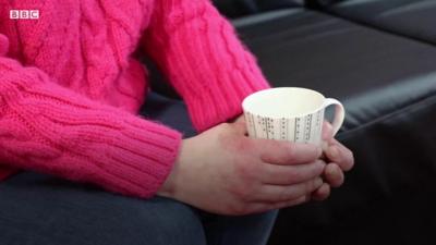 Colette holding a cup of tea