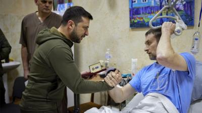 President Volodymyr Zelensky hands an award to an injured servicemen at a military hospital in Kyiv (Kiev), Ukraine, on 13 March 2022