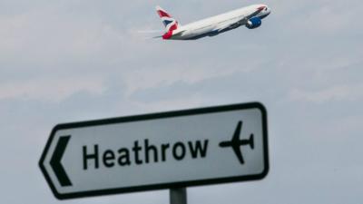 A plane flying over a Heathrow sign