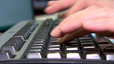 Person typing on keyboard