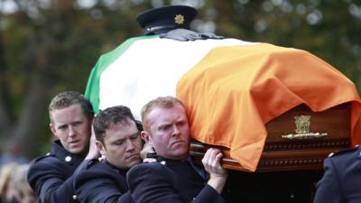 Irish police officers carry the coffin of their colleague Garda Tony Golden at his state funeral in County Louth