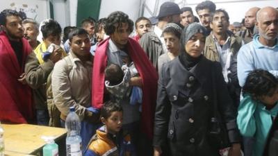 Migrants queue as they arrive in an emergency shelter at the Hungarian-Austrian border in Nickelsdorf, Austria