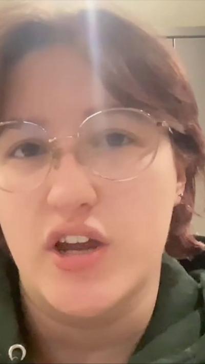 A young woman with glasses looking at the camera