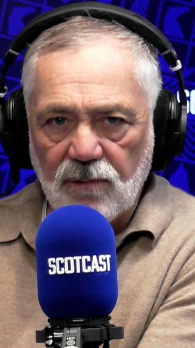 David Wilson - man with white hair and beard wearing headphones and speaking into a blue Scotcast branded microphone
