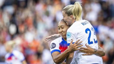 Lauren James embraces her teammate on the football pitch.