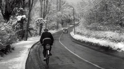 A cyclist on a snowy road.