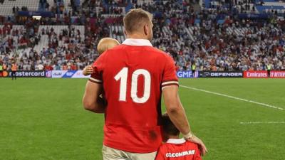 Dan Biggar with his children showing the 10 shirt